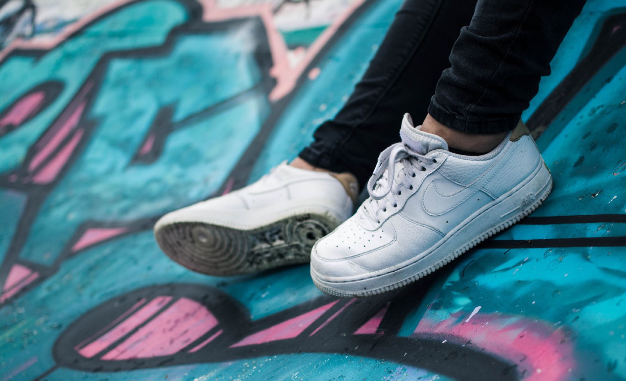 White Air Force 1s on a painted wall